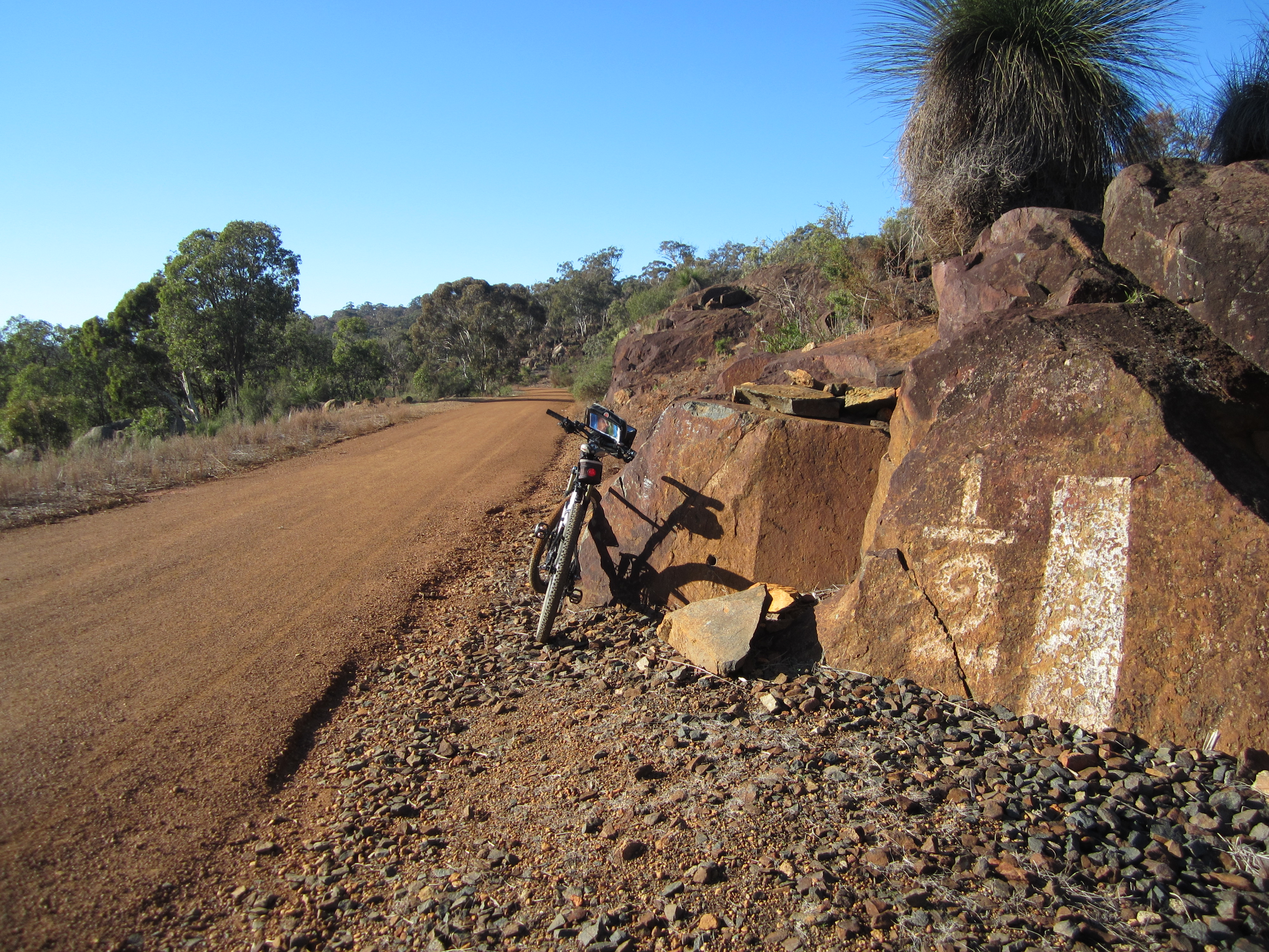 Old marker painted on rock near rail trail